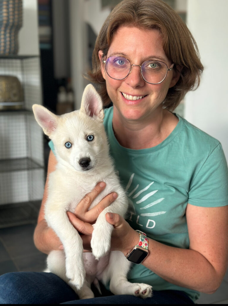 Dr Céline DUJARDIN tenant un chiot pomsky blanc